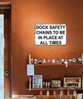 Heavy Duty Aluminum Dock Safety Chain Sign 12X8 Inch Rustproof Metal Warning Plate on wall in indoor setting.