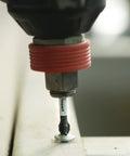 Close-up of a tool using a 2-inch square two impact tough screwdriving bit with extended torsion zone in action on a metal surface.