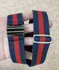 Hand holding a striped blue and red belt with shiny metal buckle and adjuster. Interlocking Metal Belt Buckles Set Of 15 For DIY Belts and Leather Straps Rectangle Quick Release Clips In Black Gold Silver Adjustable Fasteners For Women And Men not visible.