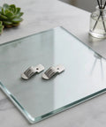 Stainless Steel Clips With Elastic Adjustment For A Secure Mount And Tough Back Mount Brackets For Organizer Shelves And Towels In Finished Spaces 50 Pack on a glass surface.