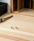 Solid 108 Piece Stainless Steel Screw Kit With Matching Nuts And Washers on a wooden workbench with tools.