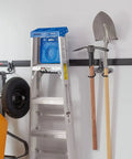 FastTrack Ladder Hook Wall Mount System with tools, ladder, and handles organized in a garage on a steel rail.