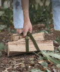 Person using Heavy Duty Ratchet Tie Down Straps Pack Of Four to lift firewood in a forest setting with green polyester webbing.