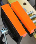 Pro Level Knockout Magnetic Vise Jaw Pads 2 Pack with orange waffle cushion on bench vise for metalworking