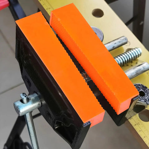 Pro Level Knockout Magnetic Vise Jaw Pads 2 Pack with orange waffle cushion on bench vise for metalworking