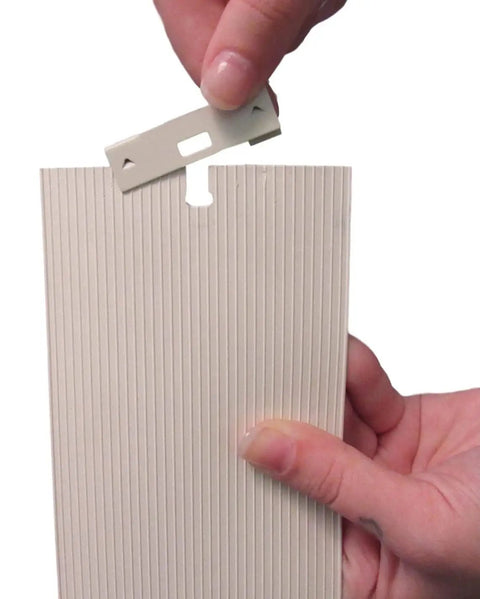 Person holding Vertical Blind Repair Clips With Curved Vane Saver for Window Blinds, installing on slat, white 15 pack.