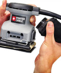 Person holding Palm Sander 1 Quarter Sheet 380 with 2.0 Amp Motor, lightweight design, showing dust bag attachment.