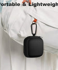 Black Carry Anywhere EVA Earbud Case with Carabiner attached to a white bag, portable for wired and wireless earphones