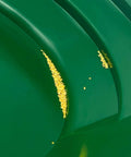 Close-up of green pan from Dual-Sided Gold Panning Kit With Vanishing Riffles For Maximum Gold Recovery, showing trapped gold flakes.