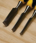 Close-up of Three Piece Chisel Set With Hardened Chrome Carbon Steel Blades, Short Series For Extra Control on wooden surface.