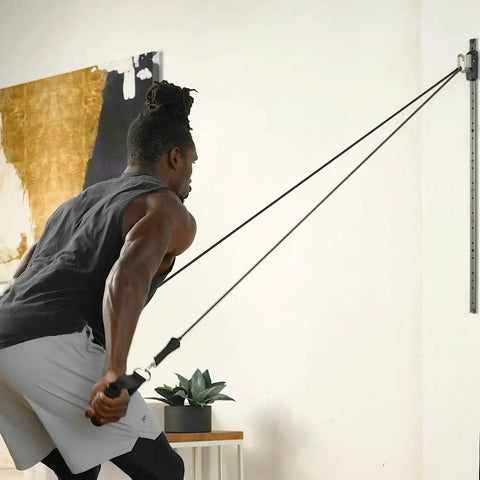 Top Tier Space Saving Home Gym Resistance Band System With Gliding Wall Track Three Foot Aluminum Mount And Five Bands Plus Handles to Kill Your Workout Grind Daily, showing a user exercising with resistance bands.