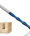 Close-up of 1/4 in shank upcut spiral router bit (2-flute carbide, blue-coated) beside a wood mortise sample