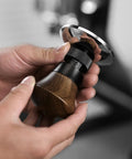 Person holding a 58.35mm Espresso Tamper With Spring Loaded Return And Adjustable Depth Pro Grade Stainless Steel Ripple Base