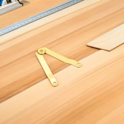 Golden Iron Lid Support Hinges With Smooth Opening And Closing lying on wood surface near ruler