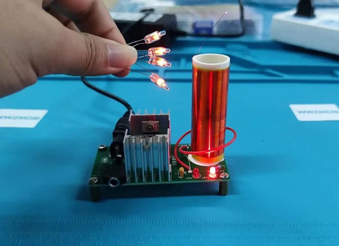 Mini DIY Tesla Coil Kit For Adults That Sings And Transmits Power Wirelessly Lights Fluorescent Lamps And Delivers Epic Arcs While You Practice Soldering Includes 15 To 24 Volt DC Power 2 Amp And 3.5 Millimeter Audio Input. handheld lit Tesla coil kit with copper secondary coil and circuit board