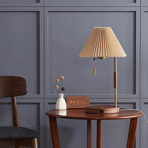 USB Wireless Charging Desk Lamp With Wood And Gold Finish on a wooden table, gray panel wall backdrop