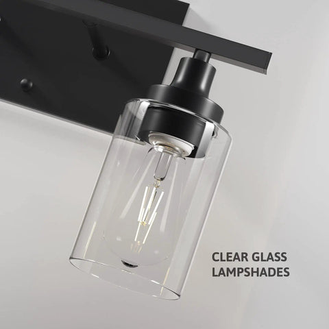 Close-up of a black metal wall sconce with clear glass lampshade, part of a 2 Light Black Industrial Bathroom Vanity Light Over Mirror Wall.