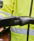 Slick Heavy Duty Type One Electric Vehicle Charging Station Diagnostic Adapter in use, testing connector, hand gripping plug.
