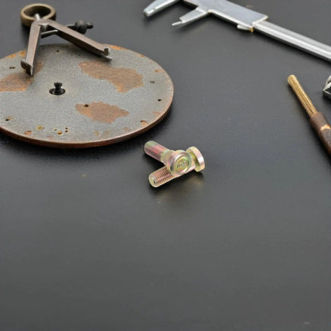 Secure Your Wheels With These 2 Pack M10 Wheel Lug Bolts Metal Studs close-up on a workbench with tools, highlighting their finish.