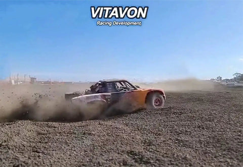 RC truck racing on dirt track demonstrating planetary gears housing for UDR Traxxas Unlimited Desert Racer 1to7