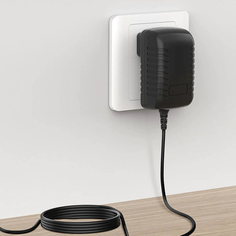 Wall AC Power Adapter For Casio AD-E95100B Keyboard plugged into wall showing black slim design and cable on wooden surface
