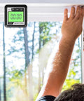 Knockout Performance Digital Angle Finder With Heavy Duty Magnetic Base And Bright Backlit Lcd Display functions as a sleek protractor inclinometer level box for dead on accuracy, held above a window frame.