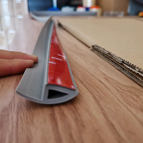 6.6 Ft Long Floor Transition Strip Edge Reducer gray with self-adhesive backing, beveled ramp on hardwood surface.