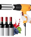 Zap A Wine Bottle Heat Shrink Gun For Fast Pvc Capsule Sealing held near three wine bottles with red caps and grapes.