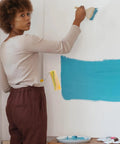 Person using a Heavy Duty Cotton Thread Paint Roller With Zero Hassle Grip And Smooth Roll Action on a wall.