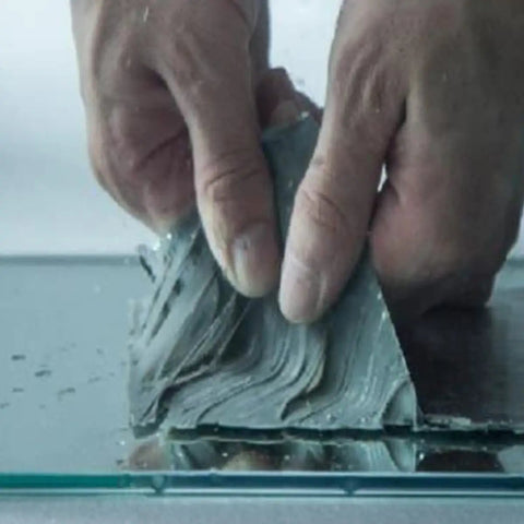 Hands applying 2 Pack Butyl Rubber Aluminum Foil Sealant Tape 5cm By 5m Weatherproof Waterproof Leak Repair on surface