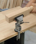 Universal Table Vise 3 Inch With 360 Degree Swivel Base in use on a workbench, holding a wooden piece securely for woodworking.