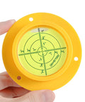 Hand holding 90mm Green Bullseye Bubble Level With Mounting Holes, Heavy Duty Pro Grade Spirit Level for RVs and Construction