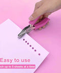 One Quarter Inch Hole Punch For Crafts With Pink Soft Grip Handle in use punching paper on pink background.