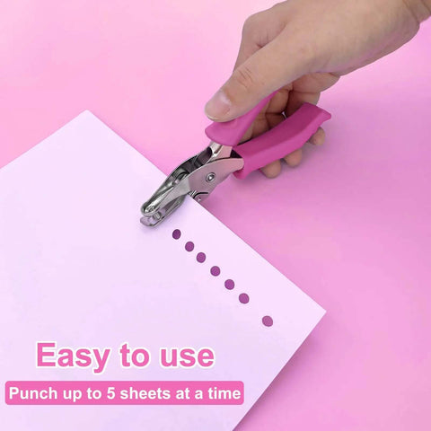 One Quarter Inch Hole Punch For Crafts With Pink Soft Grip Handle in use punching paper on pink background.