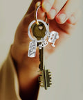 Hand holding Silver Zinc Alloy Keychain For Travel Buffs Easy To Attach And Detach Keys Compact Cute Key Ring For Vacations