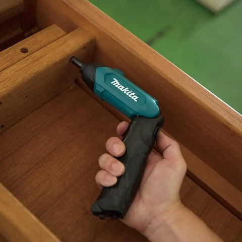 Hand holding Ultra Light Three Point Six Volt Cordless Hex Screwdriver Kit With Folding Pistol Grip in a drawer
