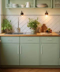 Kitchen with green cabinets featuring brushed nickel and gold cabinet pulls, sink, and countertop accessories.