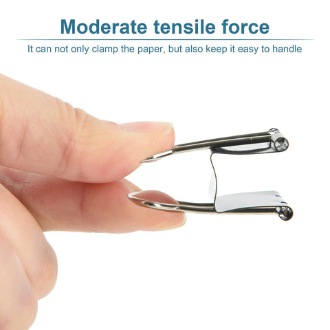 Close-up of hand holding small metal binder clip demonstrating moderate tensile force.