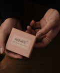 Hands holding a pink jewelry box, labeled 'MYEARS', potentially containing Gold Huggie Hoop Earrings For Women With Chunky Link Chain Cubic Zirconia 14K Gold Plated Hypoallergenic Everyday Jewelry That Goes From Casual To Dressy And Stacks With Any Look.