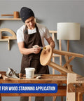 No Hassle One Inch Disposable Chip Brushes With Natural Bristles For Smooth As Butter Paint And Stain Touch Ups In A Twelve Pack Straight To Your Tool Shed Today, man staining wood furniture with brush in workshop.