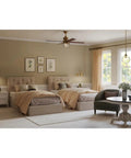 Bedroom with dual beds, beige bedding, art on walls, and a clear glass farmhouse pendant light in natural brass illuminating the room.