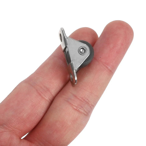 Eight Piece Low Profile Rigid Rubber Caster Wheels Non Swivel Fixed Plate Casters With Silent Rolling And Floor Saving Design For Heavy Furniture Bedroom Appliances And Small Trolleys No Sweat Moving For Your Furniture Everyday. A fixed caster wheel in hand, showcasing its compact size and sturdy metal plate for easy mounting.