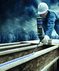 Worker applying adhesive with a Non Stick Foam Applicator Gun With PTFE Coating For Subfloor Adhesive Application Top Notch Pro Grade Spray Foam Gun That Delivers Controlled Adhesive Placement And Easy Cleanup On Wet Or Dry Surfaces