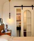 Oil Rubbed Bronze Sliding Barn Door Hardware Kit With 8 Foot Track In Brushed Antique Bronze Finish, installed in a bedroom