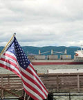 Ditch The Tangle Knot To The Curb With This Slick 360 Rotating Flag Pole Mounting Ring Clip Built For No Sweat Assembly And Bright Yard Showcase All Season Long with American flag in foreground and cargo ship in background.