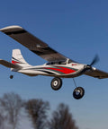 RC Airplane Apprentice STOL S 700 RTF With AS3X SAFE Technology flying in blue sky, featuring red and white color scheme.