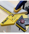 Trim 45 Trim Carpentry Aid Handheld Gauge for finishing door and window trim with adjustable reveal setting clamped on wood.