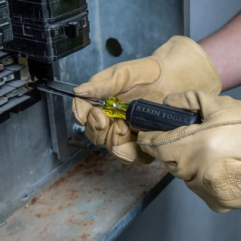 Person using a screwdriver from the Six Piece Screwdriver Set With Cushion Grip Comfort, Precision Machined Flathead And Phillips Bits, Includes Three Sixteenth Inch Cabinet Tip, One Quarter Inch And Five Sixteenth Inch Keystone Tips, Made In USA on an electrical panel