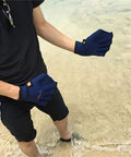 Person wearing Webbed Swim Gloves For Water Training Neoprene Paddling Gloves With Adjustable Velcro Wrist Resistance Boost in sand
