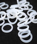 White Silicone O Ring Set With 10 Piece Assortment Thickness 2mm 2.4mm 3mm And 4mm Ideal For Sealing In Pipelines Industrial Equipment Food Processing And Automotive Use Durable Food Grade Gasket Kit, assorted white silicone O-rings on black background
